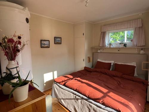 a bedroom with a bed with red sheets and a window at Home away from home in Unnaryd in Unnaryd