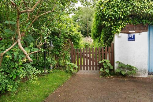 a wooden fence with a gate and a house at Ferienwohnung Haus Fahrenkrog in Wittmoldt