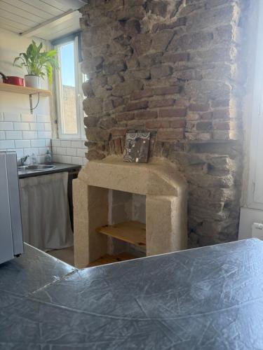 une cheminée en pierre dans une cuisine avec un mur en pierre dans l'établissement le liziec, à Vannes