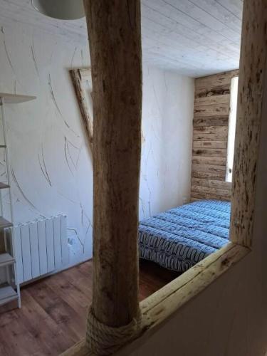 une chambre avec un lit dans le coin d'une pièce dans l'établissement le nid des choups le petit duplex 2 personnes, à La Bourboule