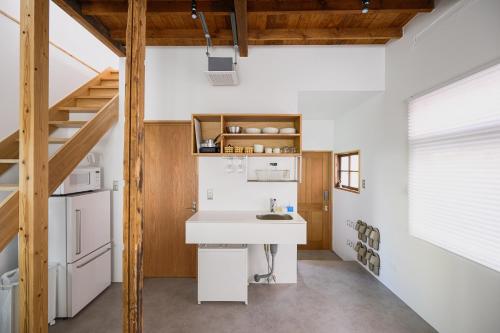 a kitchen with a white sink and a staircase at Cube Sangenjaya in Tokyo