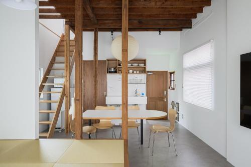 a dining room and kitchen with a table and a staircase at Cube Sangenjaya in Tokyo