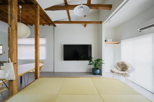 a living room with a television and a chair at Cube Sangenjaya in Tokyo