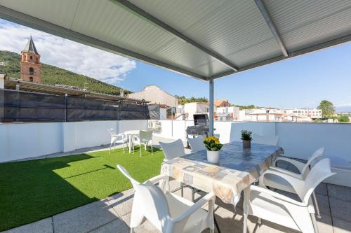 a patio with a table and chairs on a roof at La Casa de la Buhardilla in Fondón