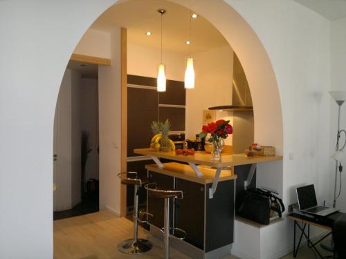 une arche dans une cuisine avec un comptoir et des tabourets dans l'établissement Bel appartement 80m2 vue sur mer, à La Ciotat