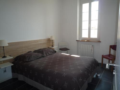 une chambre avec un lit noir et une fenêtre dans l'établissement Bel appartement 80m2 vue sur mer, à La Ciotat