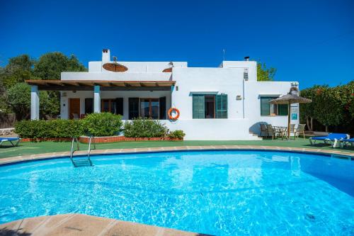 a villa with a swimming pool in front of a house at Apto Felipe 1-2 vista piscina in Cala d´Or