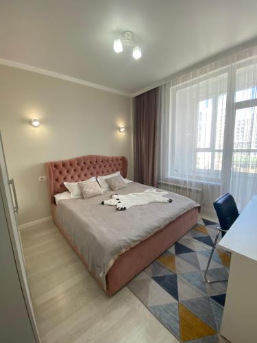 a bedroom with a large bed and a window at Sat City block A in Astana