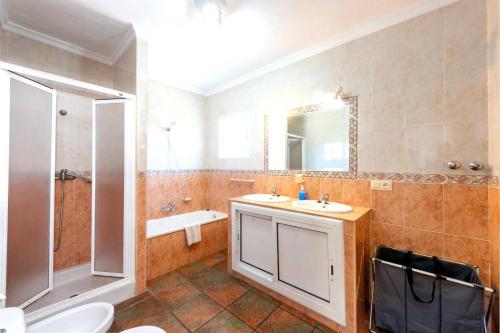 łazienka z 2 umywalkami, prysznicem i toaletą w obiekcie Villa Sanchez Sol by Villa Plus w mieście Torrox