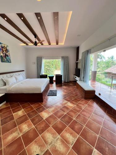 a bedroom with a bed and a tiled floor at Riverside Luxury Private Pool Villa in Athirappilly in Athirappally