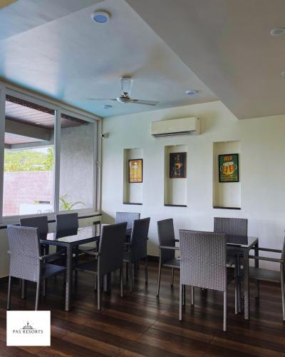 a dining room with tables and chairs and a window at PAS Resorts in Anjuna