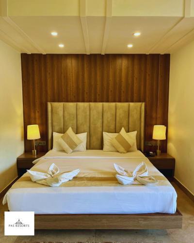 a bedroom with a large bed with two white bows at PAS Resorts in Anjuna
