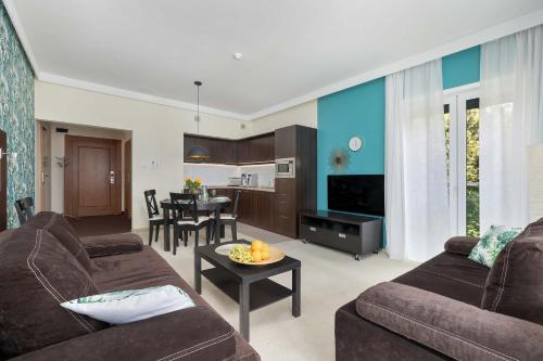 a living room with two couches and a dining room at Family Apartment with Air Conditioning in Mielno by Noclegi Renters in Mielno
