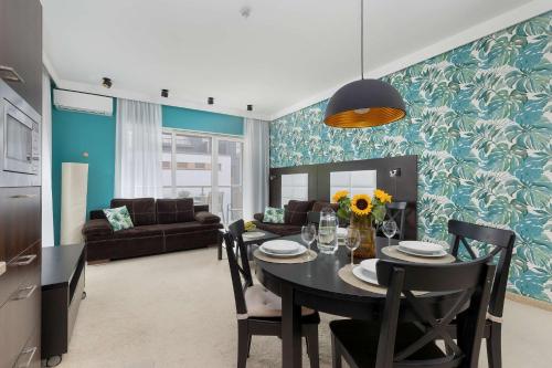 a dining room with a table and a living room at Family Apartment with Air Conditioning in Mielno by Noclegi Renters in Mielno