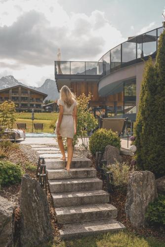 a woman walking up some stairs in front of a building at Hotel Wagnerhof in Pertisau