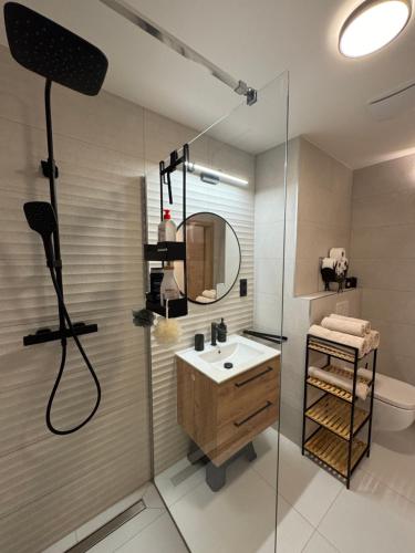 a bathroom with a sink and a shower with a mirror at Luxury Mountain Apartment in Janske Lazne