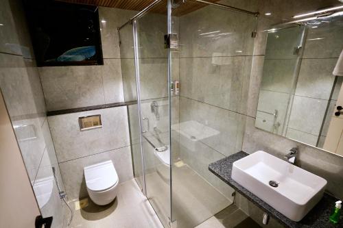 a bathroom with a shower and a toilet and a sink at Bhumiputra stays in Pernem