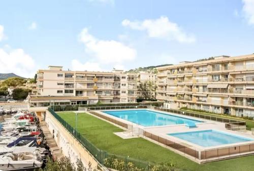 un complexe d'appartements avec une grande piscine dans l'établissement La Palme d'Or - Piscine, Pétanque et Port, à Mandelieu-la-Napoule