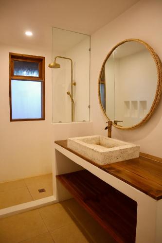 a bathroom with a sink and a mirror at Padel and Palms Villas in General Luna