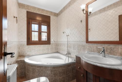 a bathroom with a tub and a sink at Cortijo Era del Realenguillo in Villanueva de la Concepción