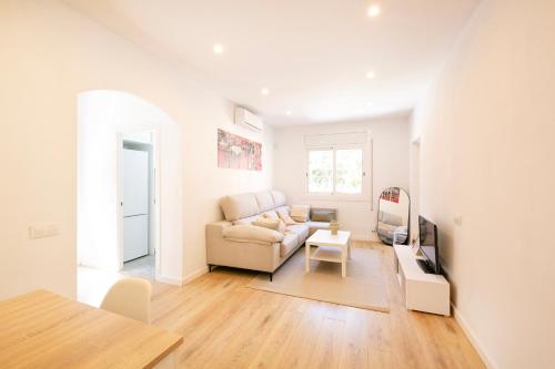 a white living room with a couch and a table at Lovely apartment with 3 bedroom in Cornellà de Llobregat
