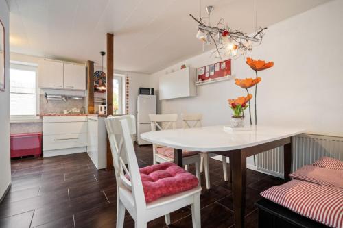 Una cocina y un comedor con mesa y sillas. en Rose, en Burg auf Fehmarn