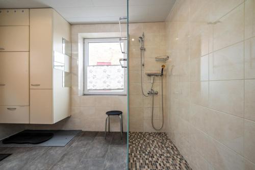 y baño con ducha y taburete. en Rose, en Burg auf Fehmarn