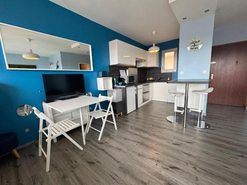 une cuisine et un salon avec une table et des chaises dans l'établissement L'azur cosy studio Meyzieu, à Meyzieu