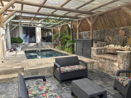 um pátio com piscina, cadeiras e uma mesa em Bay Complex (The) em Grand Baie