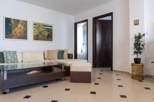 a living room with a couch and a table at Делукс Апартамент Лазур Поморие in Pomorie