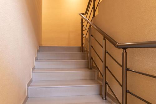 a stairway with white stairs and a railing at Делукс Апартамент Лазур Поморие in Pomorie