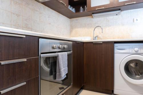a kitchen with a washing machine and a sink at Делукс Апартамент Лазур Поморие in Pomorie