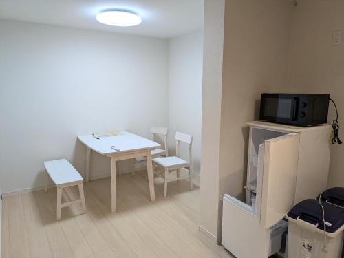 a small room with a table and chairs and a tv at amuseria in Kyoto