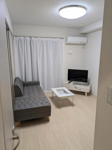 a living room with a couch and a television at amuseria in Kyoto
