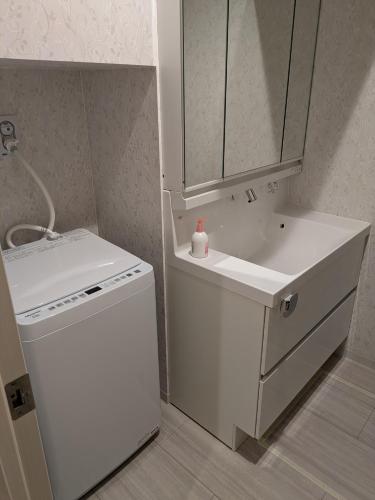 a small kitchen with a white sink and a white dishwasher at amuseria in Kyoto