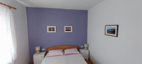 una camera da letto con una parete blu con un letto di Apartments Darija a Sveti Petar