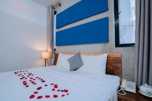 a bed with a bunch of red roses on it at Home Chic Hotel in Phnom Penh