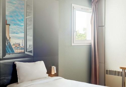 Ένα ή περισσότερα κρεβάτια σε δωμάτιο στο B&B HOTEL Montlhery
