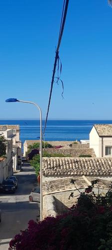 a view of the ocean from a street with a street light at Casa Iolanda in Donnalucata