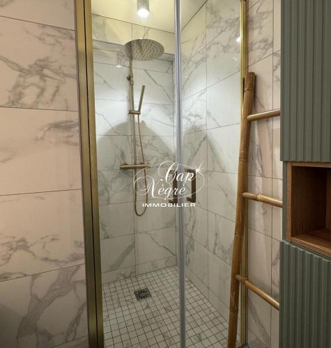 une douche avec une porte vitrée dans une salle de bain dans l'établissement mazet duplex terrasses plein sud residence avec piscine, à Aigue-Belle