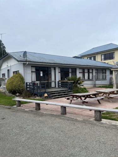 a building with picnic tables in front of it at Quiet country setting- R3 Magnolia House in Temuka