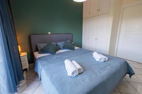 a bedroom with a blue bed with towels on it at Breathing Apartment in Virós