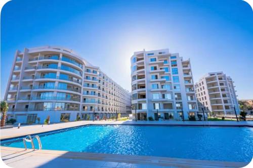 a swimming pool in front of two tall buildings at Domi Chalet in Hurghada