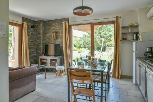 une cuisine avec une table avec des chaises et une salle à manger dans l'établissement Gite Entre lacs et montagne, à Saint-Bueil