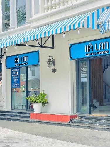 eine Ladenfront mit blauen Markisen an einem Gebäude in der Unterkunft Hà Lan Homestay - GrandWorld in Phu Quoc