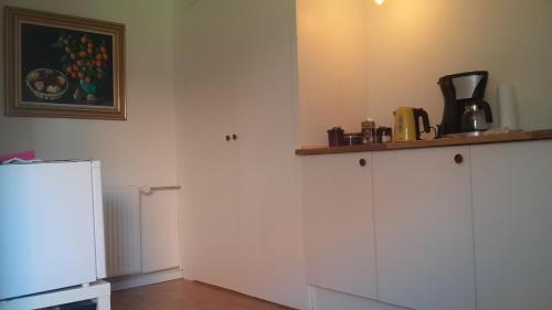 a kitchen with white cabinets and a refrigerator at Room In Gedser Centrum in Gedser