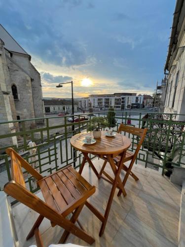 a wooden table and two chairs on a balcony at Central View Apartment in Turda