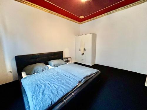 a bedroom with a bed with blue sheets and a ceiling at HONOR - Urban Peace Linz in Linz