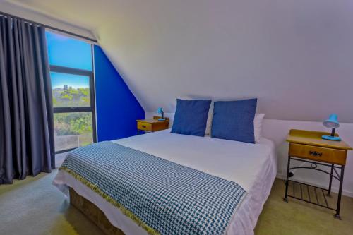 a bedroom with a bed and a large window at Widdy's Beach Club in Widenham