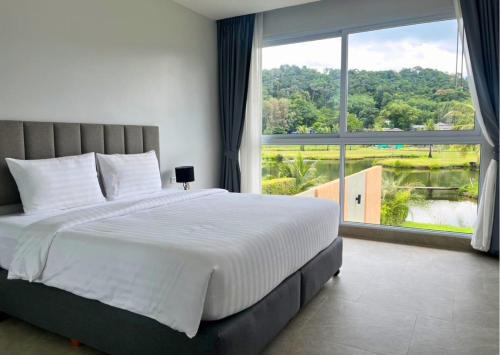 Ban Khlong SonにあるWhite Lotus Pool Villa Koh Changの大きなベッドと大きな窓のある寝室